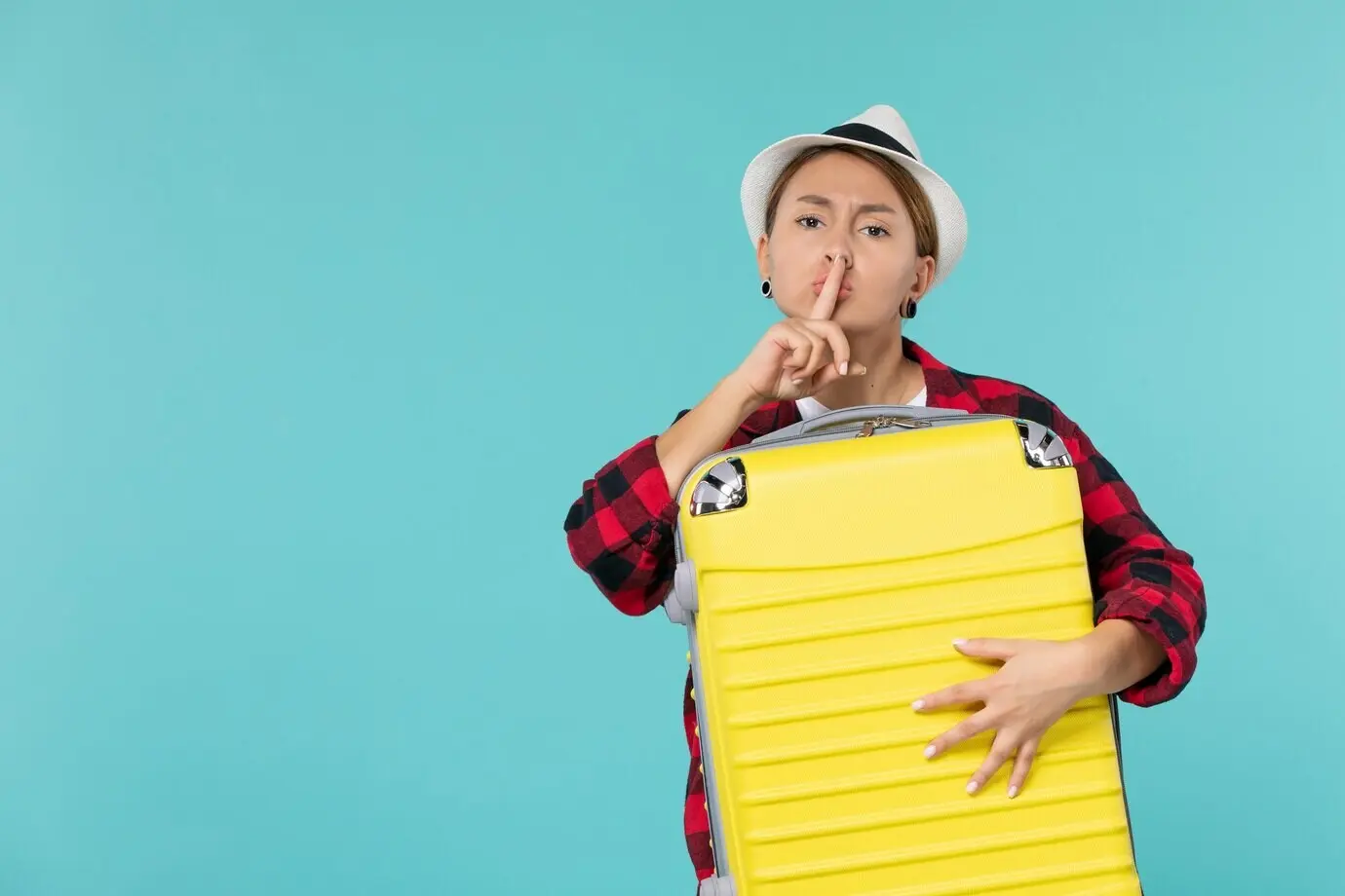 Вид спереди: молодая женщина, отправляющаяся в отпуск с ее большой сумкой на синем полу; морское путешествие, путешествие, поездка, самолет